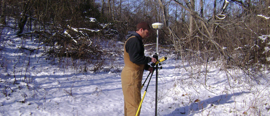 Surveyor operating field equipment in winter
